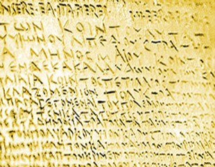 Un esempio di scrittura in greco arcaico incisa su una lamina d'oro. An example of archaic Greek writing engraved on a gold foil.